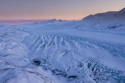 Scenic view of snow covered mountains against sky during sunset