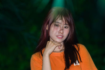 Portrait of young woman outdoors at night