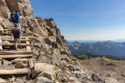 Rear view of father and son climbing steps on mountain