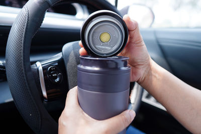 Cropped hand of man holding steering wheel