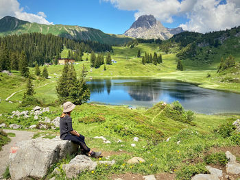 Woman looking at lake against mountain