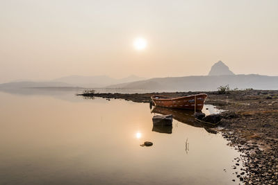 Scenic view of lake against sky during sunset