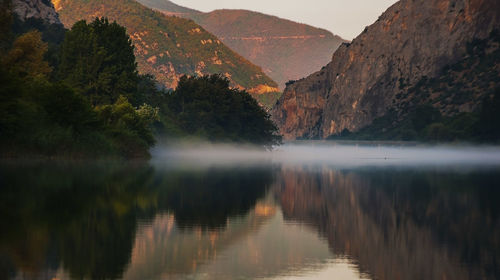 Scenic view of lake and mountains against sky