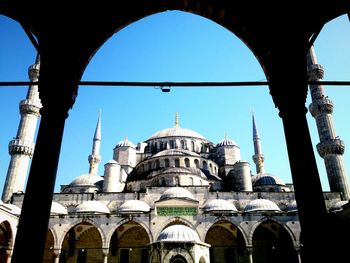 Low angle view of mosque against blue sky