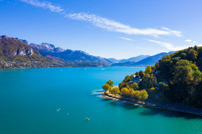 Scenic view of sea and mountains against blue sky