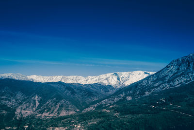 Scenic view of mountains against blue sky