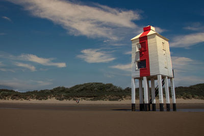 Lifeguard hut on beach against sky