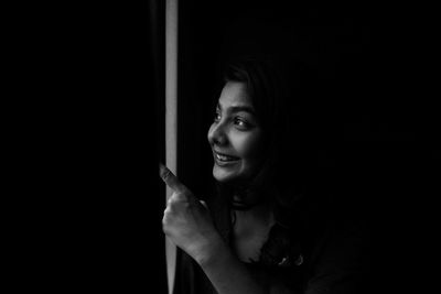 Happy young woman in darkroom looking away