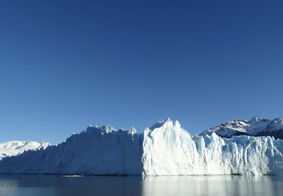 Scenic view of snowcapped mountains against clear blue sky