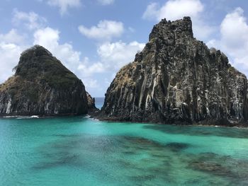 Scenic view of rock formation in sea against sky