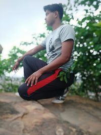 Side view of young man sitting outdoors