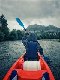 Rear view of man boating on lake