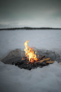 Campfire against sky during winter