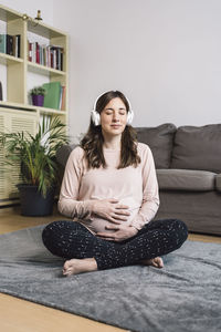 Young woman sitting on sofa at home