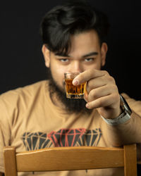Close-up of young man drinking wine at home