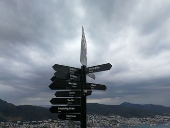 Low angle view of sign on mountain against sky