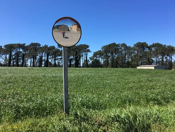 Information sign on field against clear sky