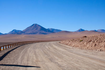 Railing on desert against clear blue sky