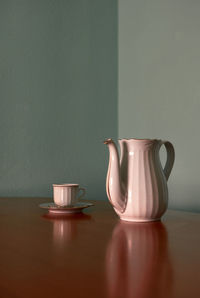 Coffee cup and teapot on a corner table. conceptual image