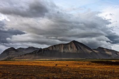 Scenic view of landscape against dramatic sky