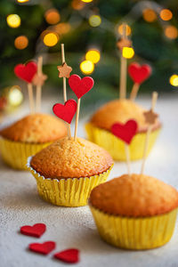 Valentine's day dessert, cupcakes decorated with wooden hearts on white table. front view