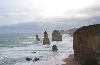 Rocks on sea shore against sky