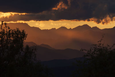 Scenic view of silhouette mountains against sky at sunset