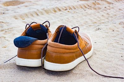 Close-up of shoes at beach