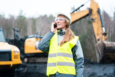 Female engineer talking on phone at construction site