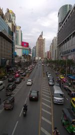 Traffic on city street and buildings against sky