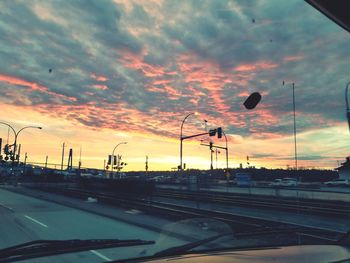 Cars on road against sky during sunset