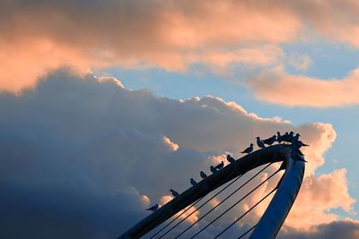 Low angle view of silhouette metallic structure against sky at sunset