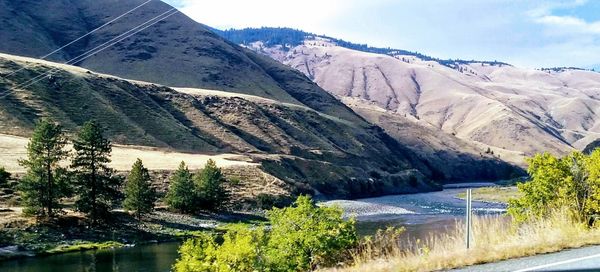 Scenic view of river and mountains against sky