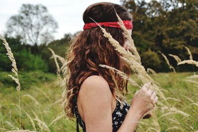 Woman holding crops on field