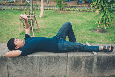 Rear view of man lying on land
