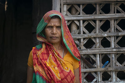 Portrait of a woman standing in front of her house