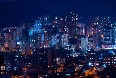 Illuminated cityscape against sky at night