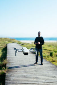 Young man flying a dron near to the beach