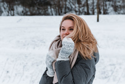 Young woman standing on snow covered field