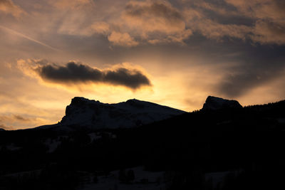 Silhouette mountain against dramatic sky during sunset