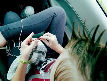 High angle view of woman crocheting wool in car