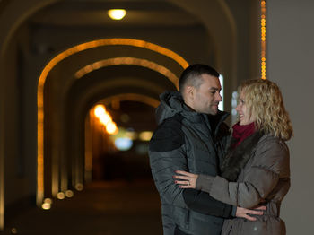 Young couple standing in illuminated tunnel