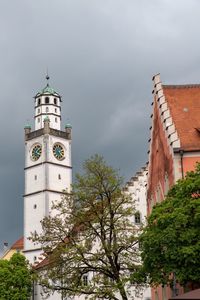 Low angle view of trees and buildings against sky