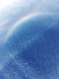 Scenic view of rainbow in blue sky