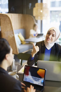 Woman in headscarf sitting in cafe