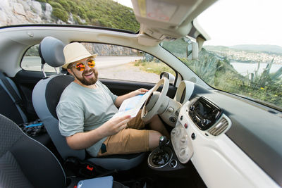 Side view of man driving car