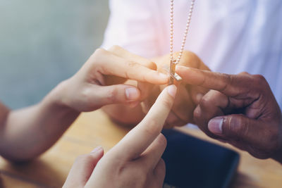 Close-up of people holding cross