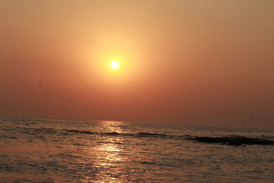 Scenic view of sea against orange sky