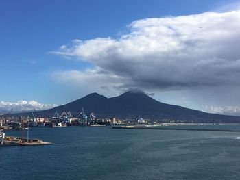 Sea by city against sky