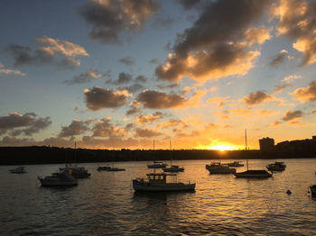 Sailboats in sea against sky during sunset